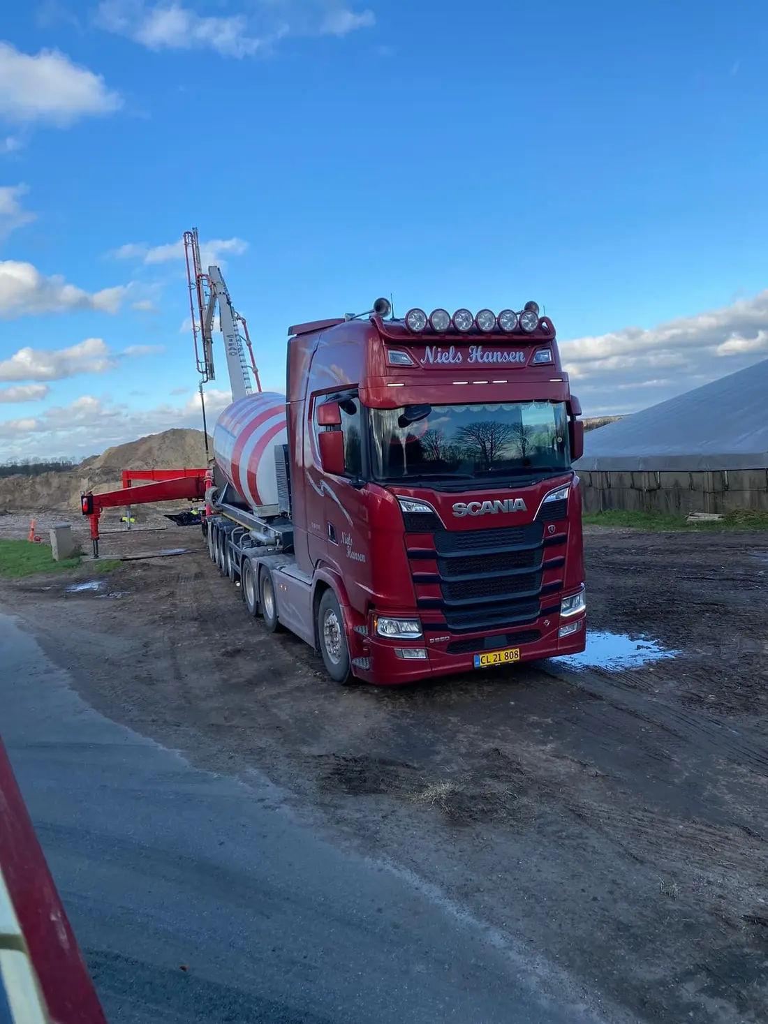 Lastbil med en stor rød og hvid tank på traileren