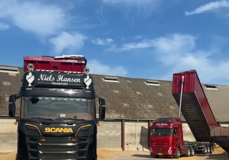 To af firmaets lastbiler på pladsen, den ene med traileren kørt op