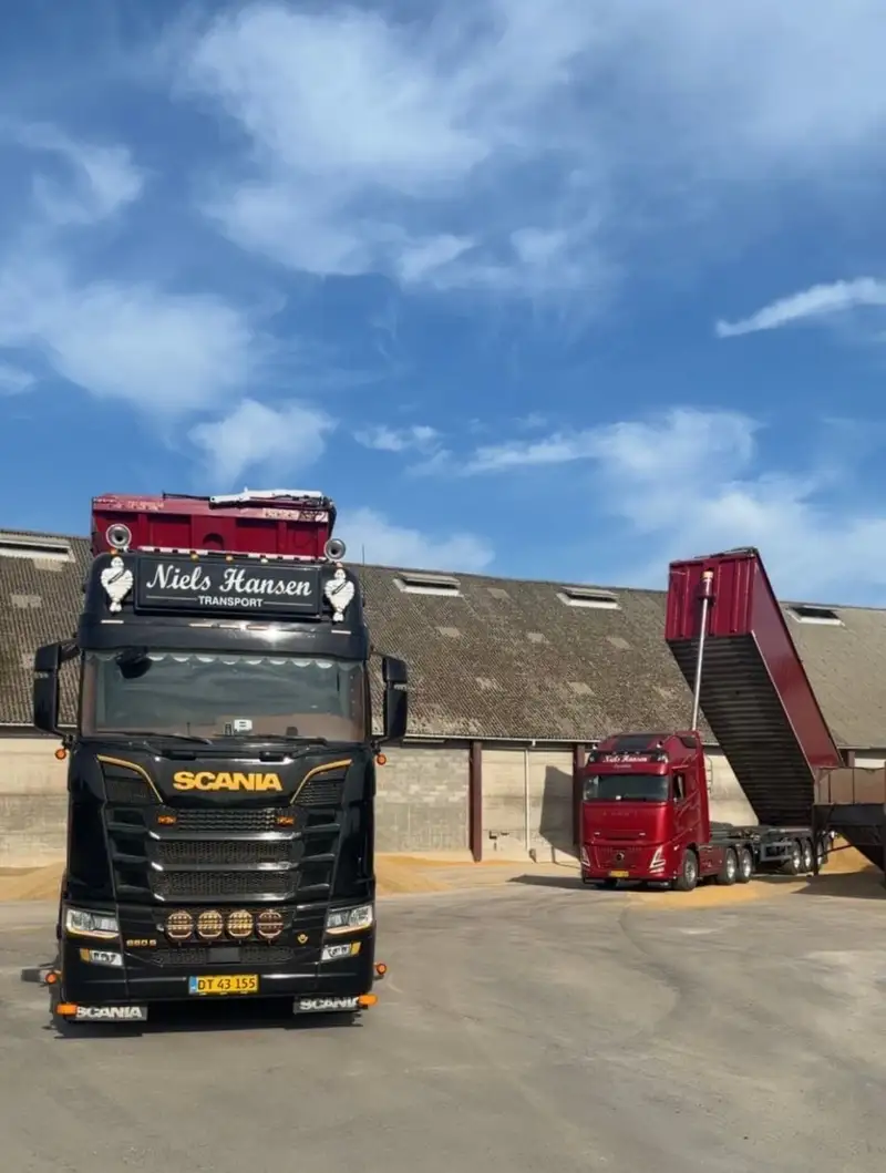 To af firmaets lastbiler på pladsen, den ene med traileren kørt op