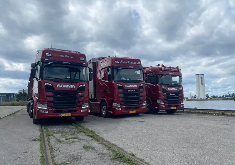 Tre af firmaets lastbiler samlet på havnen