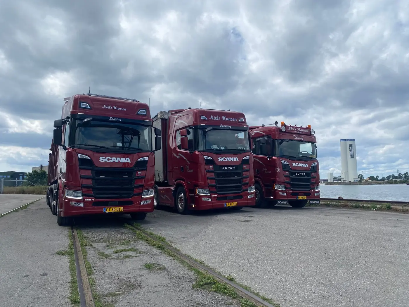Tre af firmaets lastbiler samlet på havnen